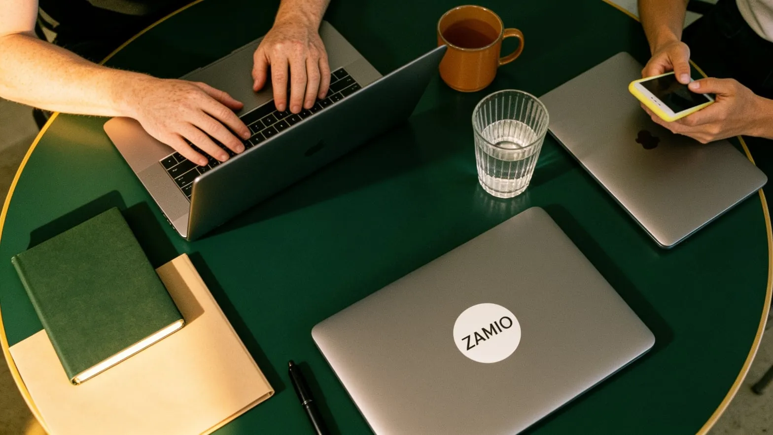 Equipe da Zamio reunida à mesa de trabalho